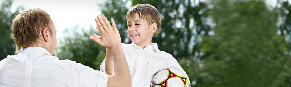 Porträtfoto: Vater und Sohn mit Fußball
